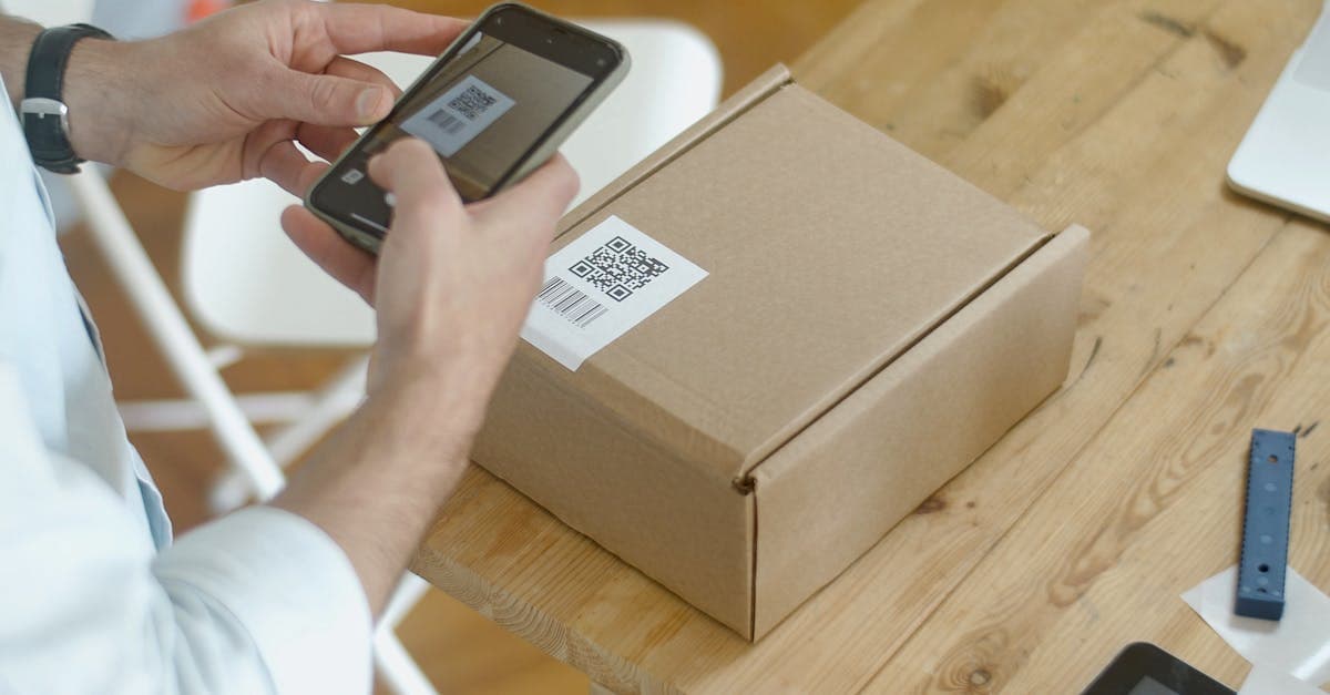 Warehouse worker scanning a product barcode with a handheld scanner at a receiving station