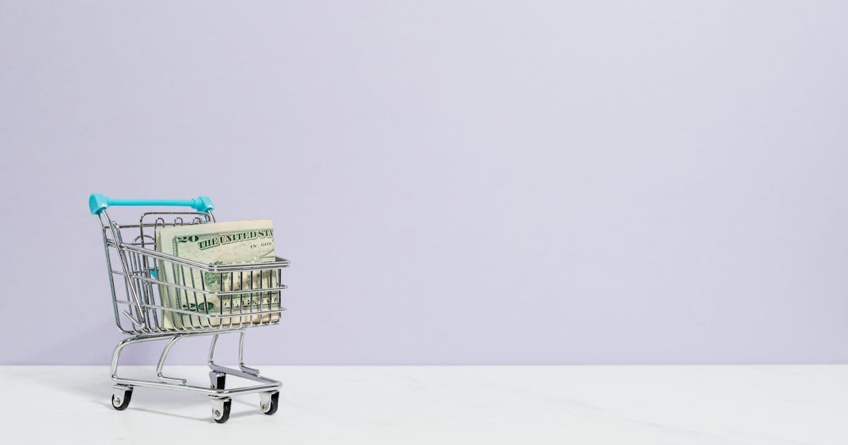 Solo ecommerce operator working on a laptop with automated dashboards showing multichannel orders and inventory in the background
