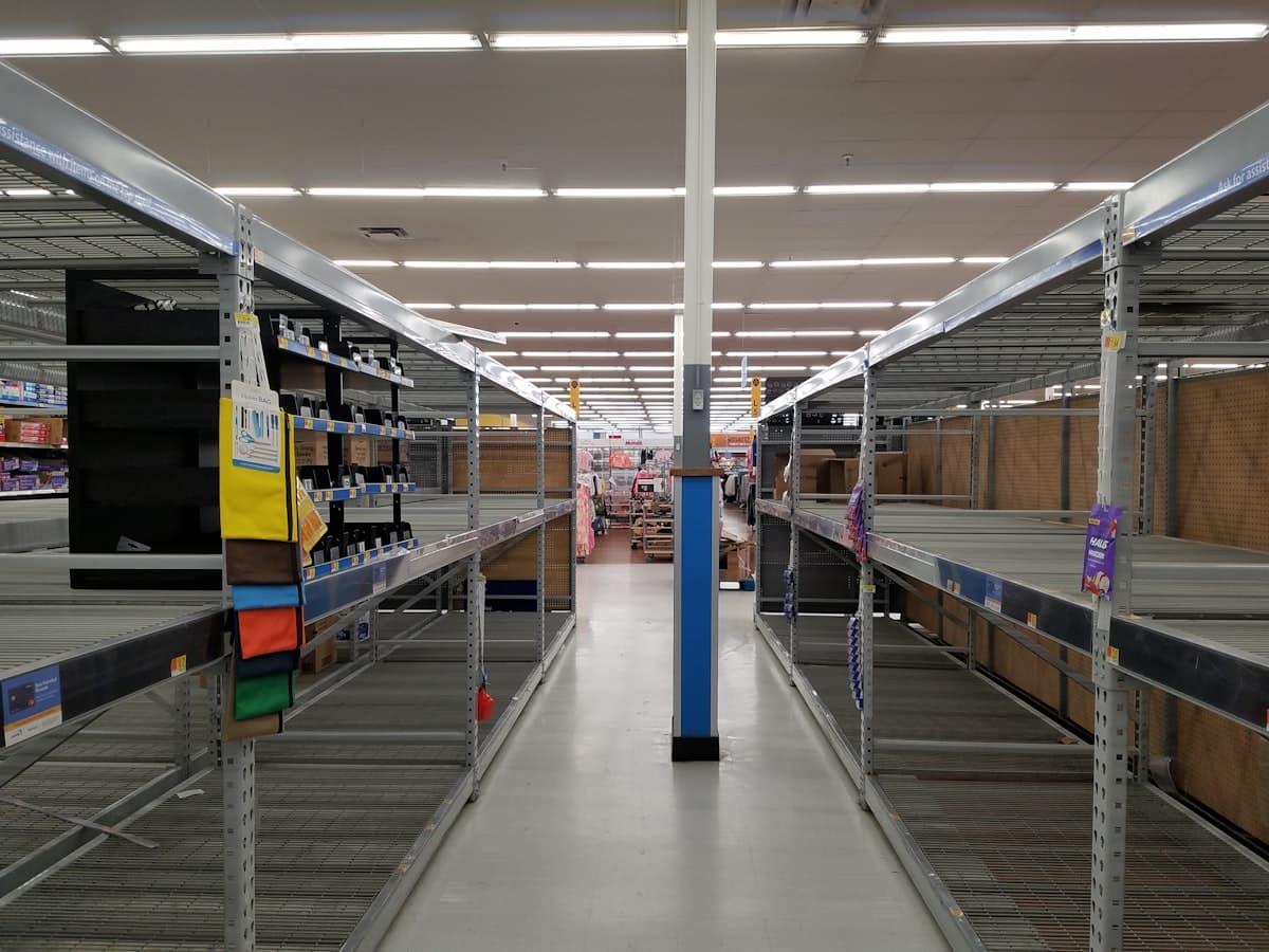 Empty warehouse shelves representing an ecommerce stockout and the cost of inventory shortages on revenue